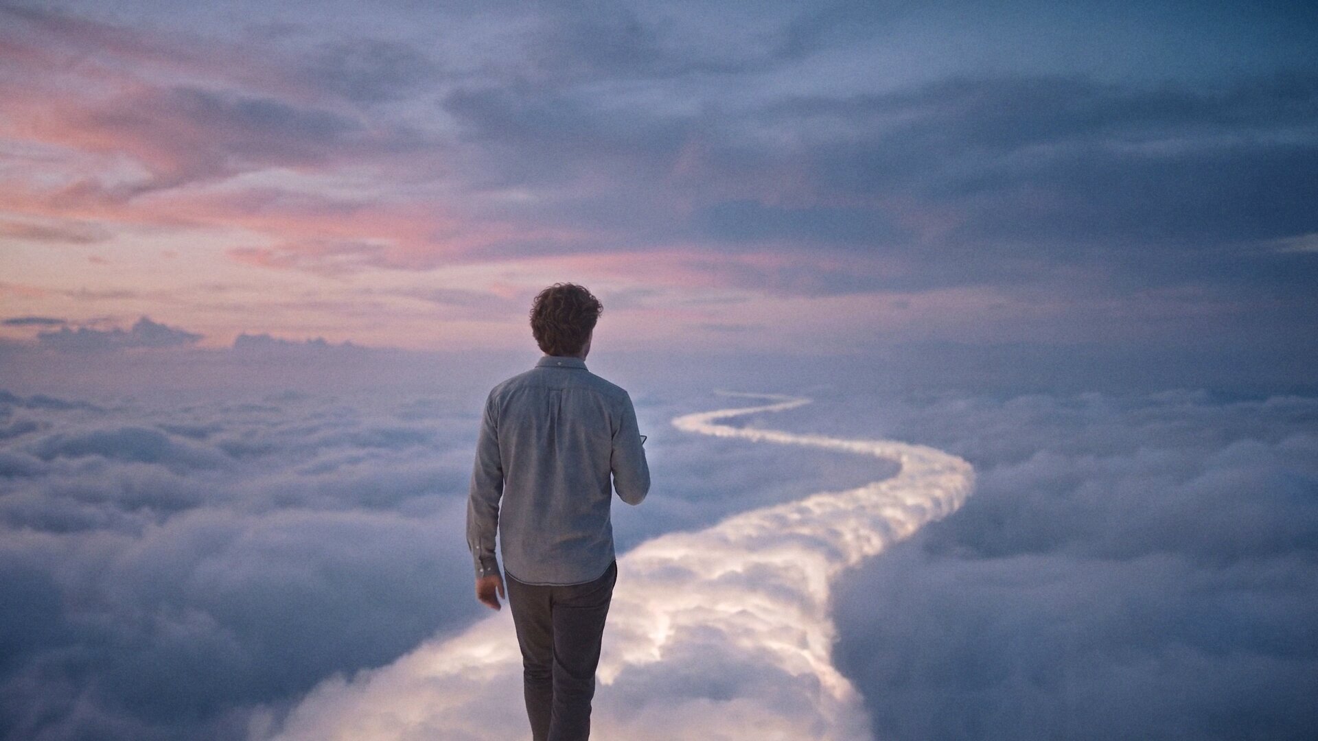 A man walks his own glowing path across the clouds